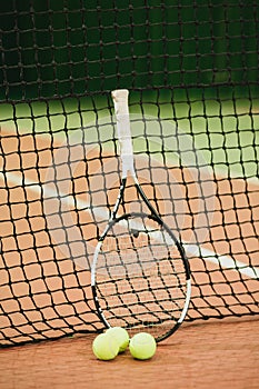 Tennis racket and 3 balls on the tennis court grid close-up. Sports Equipment photo