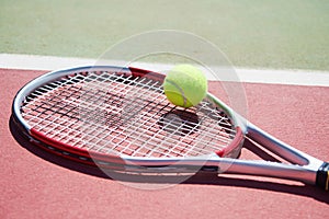 A tennis racket and new tennis ball on a freshly painted tennis court. photo