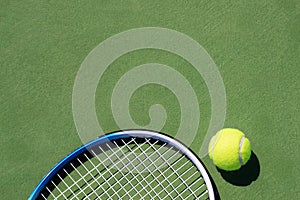Tennis racket and tennis ball on court.