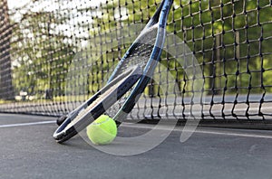 Tennis rackets and ball leaning on net
