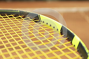 Tennis racquet against clay court close up