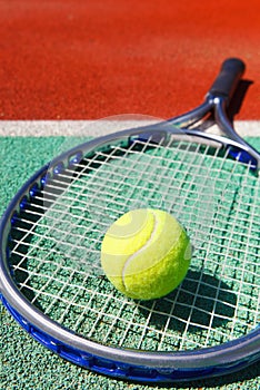 Tennis racquet and ball on the clay tennis court