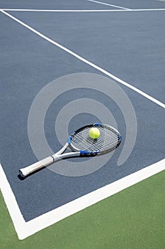 Tennis racquet and ball in court