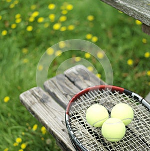 Tennis racquet and balls on the bench. Conceptual image