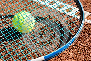 Tennis raquet with tennis ball on ash court