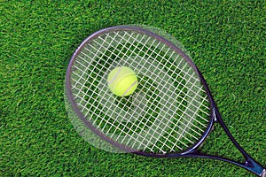 Tennis raquet and ball on grass photo