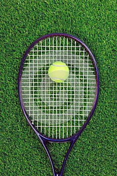 Tennis raquet and ball on grass photo