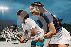 Tennis sport people concept. Mixed doubles player hitting tennis ball with partner standing near net