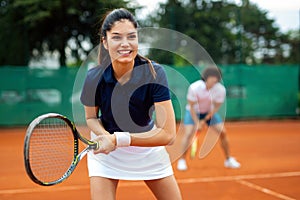 Tennis sport people concept. Mixed doubles player hitting tennis ball with partner standing near net