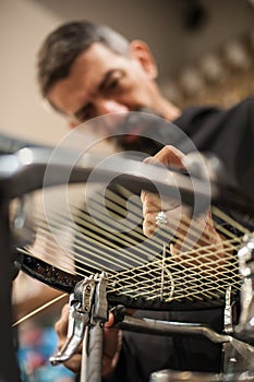 Tennis stringer holding awl and doing racket stringing