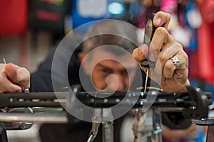 Tennis stringer holding awl and doing racket stringing