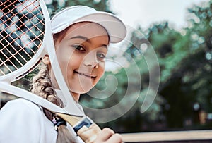 Tennis training for young kid outdoors. Portrait of happy sporty little girl on tennis court. Caucasian child in white tennis
