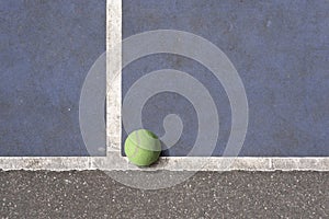 Tennisball on a blue rundown tennis court photo