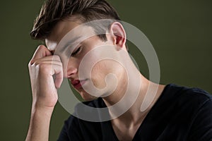 Tense androgynous man with hand on forehead photo