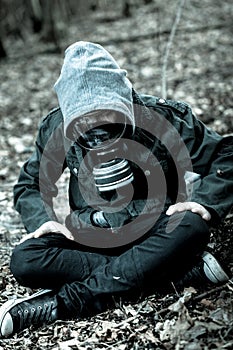 Tense child in gas mask sitting on ground