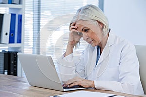 Tense female doctor working on her laptop