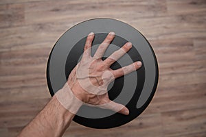 Tense thin male palm with veins on a black circle photo