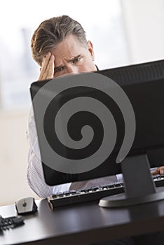 Tensed Businessman Looking At Computer Monitor