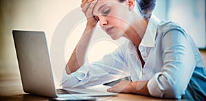 Tensed businesswoman using laptop in conference room