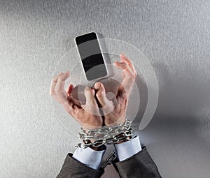 Tensed chain tied businessman hands hostage of mobile burnout