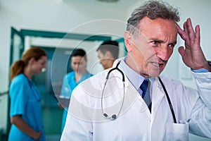 Tensed doctor standing in corridor