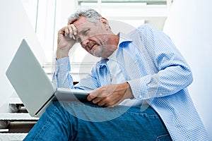 Tensed man using digital tablet on steps
