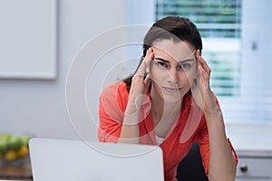 Tensed woman working on laptop