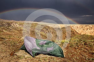 Tent broken by strong wind and a rainbow