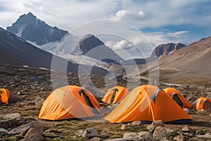 Tent camp and orange tents on the plateau of a mountain valley, the point of acclimatization of climbers before a high
