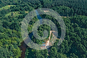 Tent Camp river green tourists on the river bank among the green forest - aerial shot