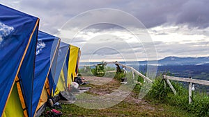 Tent in camping with flog and mountain view. Camping activities in rain-filled holiday. Tent on campsite by the hill in rainy day photo