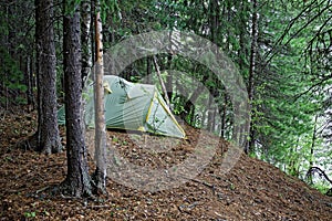 Tent installed on the steep bank of a wild Siberian river