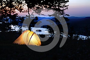 A tent lit up at dusk