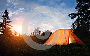 A tent lit up at dusk