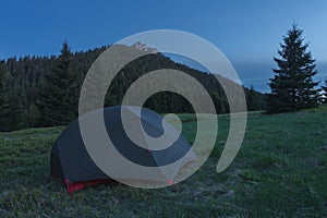Stan na horskom sedle v tráve večer. Na pozadí Veľký Rozsutec. Malá Fatra, Slovensko