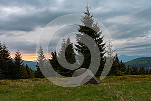 Tent on mountain col in grass in the morning. On background Mala Fatra mountains, Slovakia