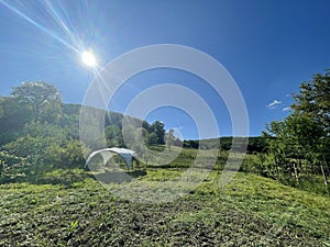 A tent pavilion on land where a campsite is to be built, Transylvania, surrounded by greenery