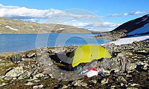 A tent stanging in rocky mountain peaks and glacier in Norway