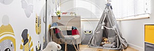 Tent with toys,colorful armchair, grey lamp and rug in smal