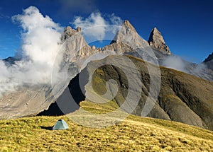 Tent under three peaks Aiguilles d'Arves in French Alps, France.