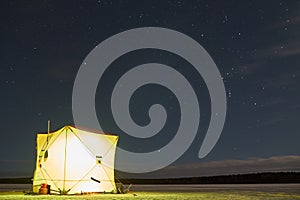 Winter fishing tent at night.