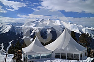 Tents cafe on the background of snowy mountain peaks.