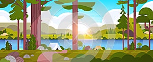 Tents camping area in forest summer camp concept sunny day sunrise landscape nature background with water mountains and