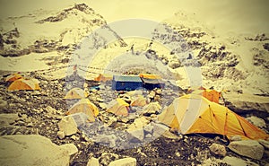 Tents in Everest Base Camp in cloudy day, vintage effect.