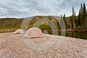 Tents at river in remote Yukon taiga wilderness