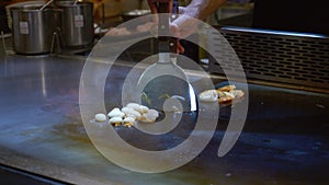 Teppanyaki Chef Cooking the Octopus an Open Hot Frying Pan in Restaurant
