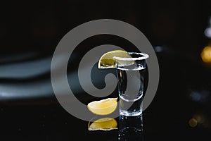 Tequila with lime on a dark background