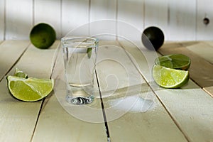 Tequila with lime and salt on a wooden background