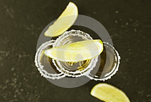 Tequila with salt and lime on a dark background. Toning