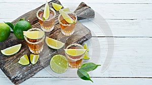 Tequila with salt and lime on a white wooden background. Top view.